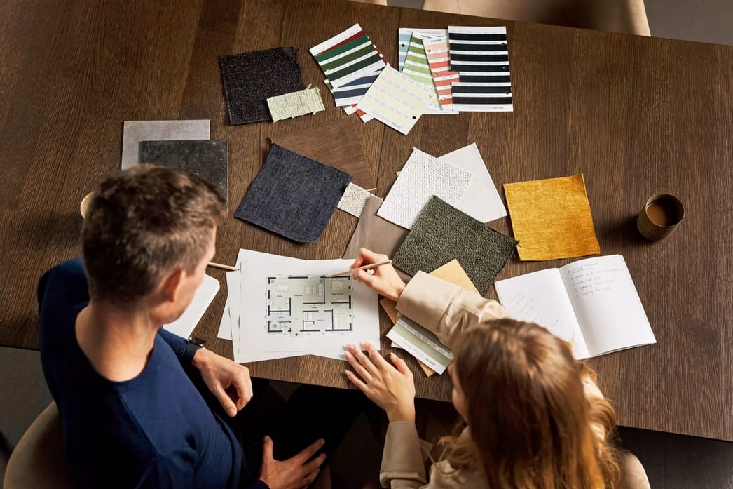 Interior designer and client reviewing samples together in a bright, modern space.