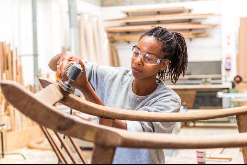 Artisan upholstering a chair as part of an interior design collaboration.